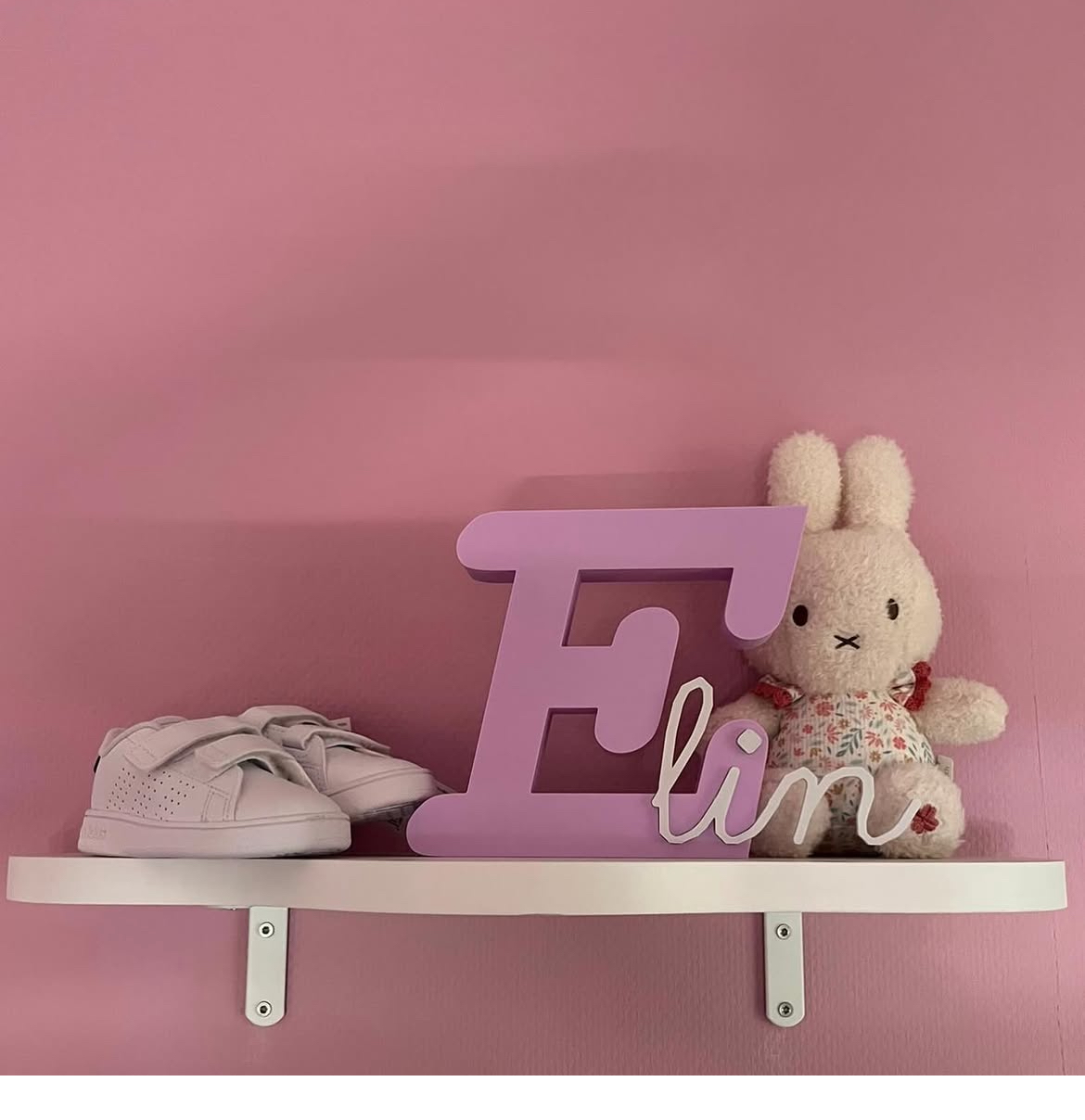 Paars met wit naamobject Elin op een plank in een roze kamer